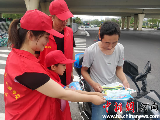 志愿者們?yōu)檫^往行人發(fā)放綠色出行宣傳單,。連柏梁 攝 志愿者們?yōu)檫^往行人發(fā)放綠色出行宣傳單,。連柏梁 攝