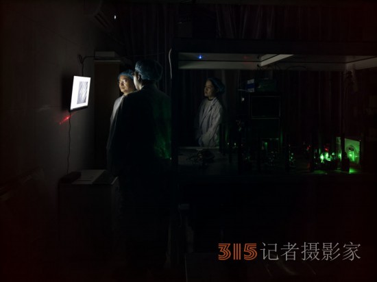 阮昊研究員（左）和他的學(xué)生趙苗（中）,、胡巧在上海光機所光學(xué)實驗室,，利用國際首創(chuàng)的雙光束調(diào)控聚集誘導(dǎo)發(fā)光超分辨光存儲技術(shù)做寫入試驗（2月29日攝）。
